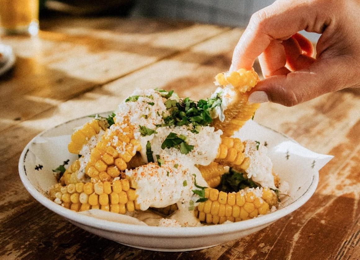 A woman takes a corn rib from a bowl at Mexican bar El Grotto in Scarborough
