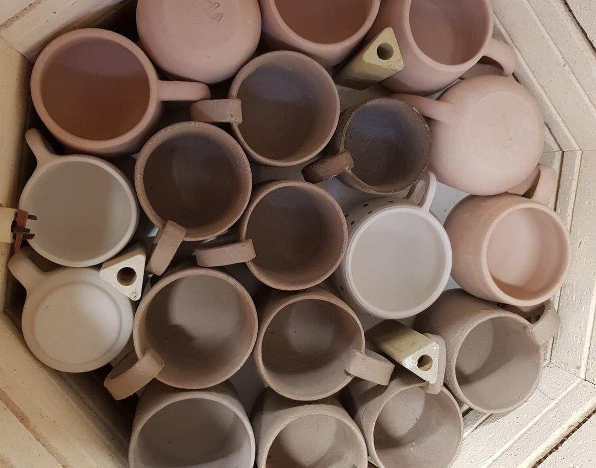 A bunch of pottery cups in a kiln at SKAPOTS. One of Perth's best beginner pottery workshops