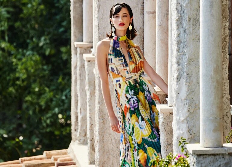 A model wearing a bright fruit patterned dress by L'IDEE. One of Perth's best womenswear brands