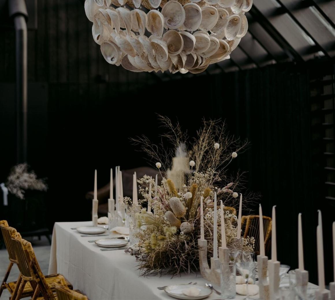 A beautiful dinner table setting under the oyster shell chandelier in the Creek House at Esperance Chalet Village