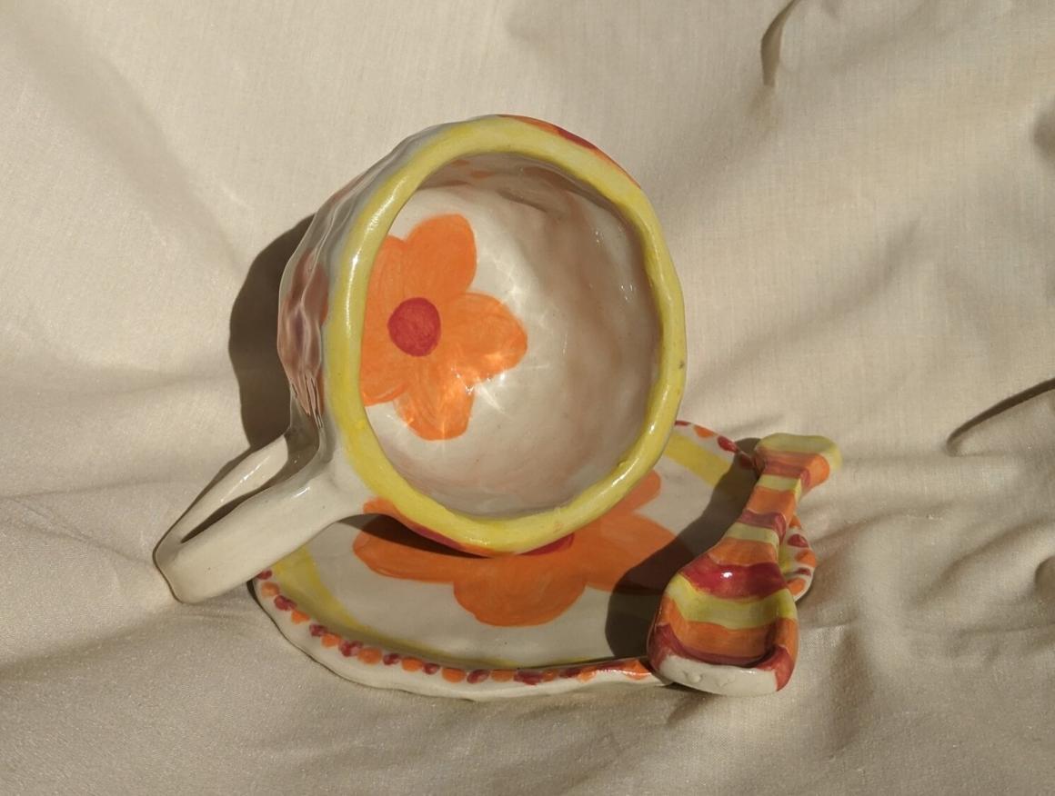 A painted pottery cup, saucer and spoon at House of Hobby. One of Perth's best beginner pottery workshops