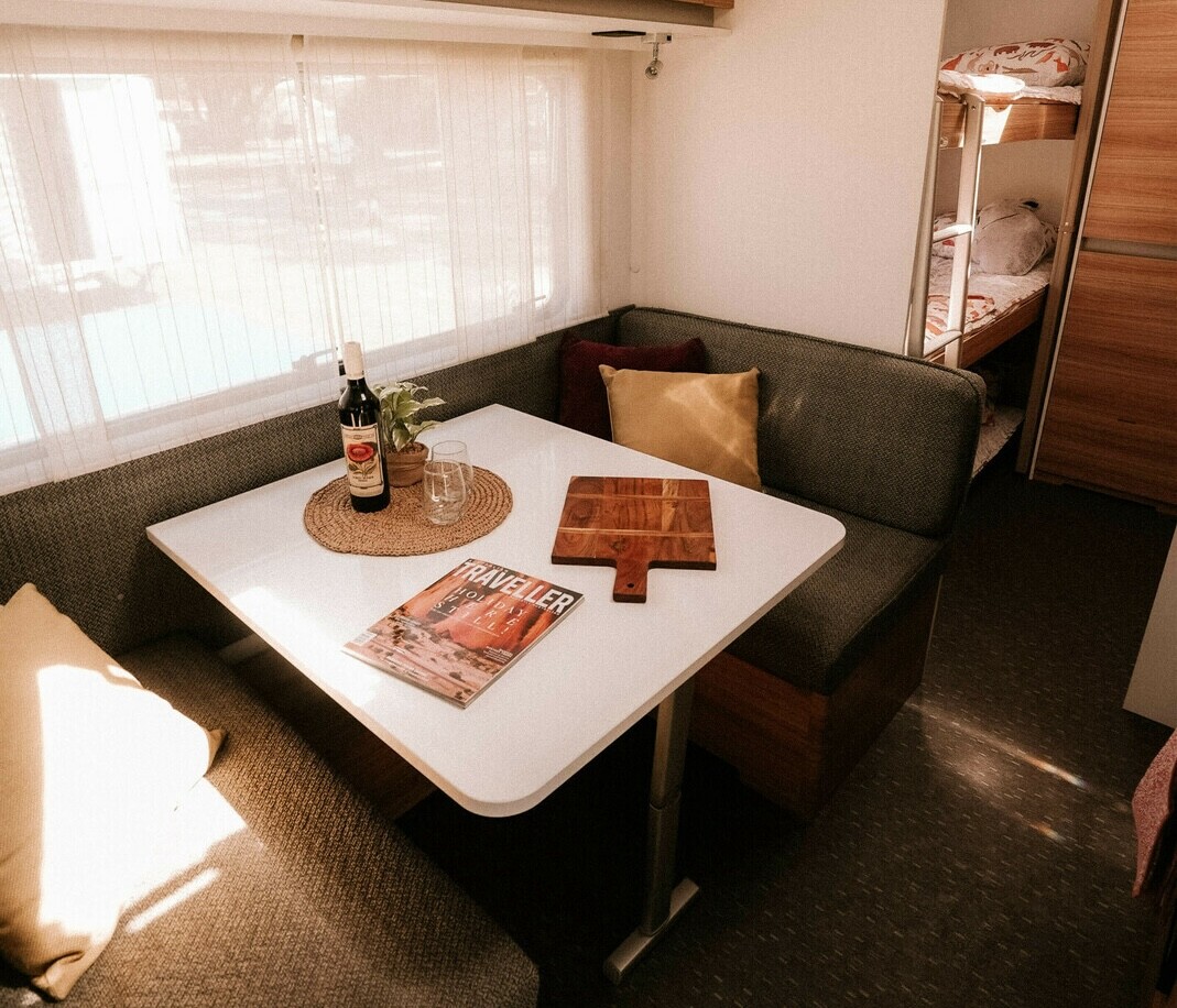 The living room of Stella the campervan. Featuring two couches and a table. This is one of the best campervans to hire in Western Australia (WA).