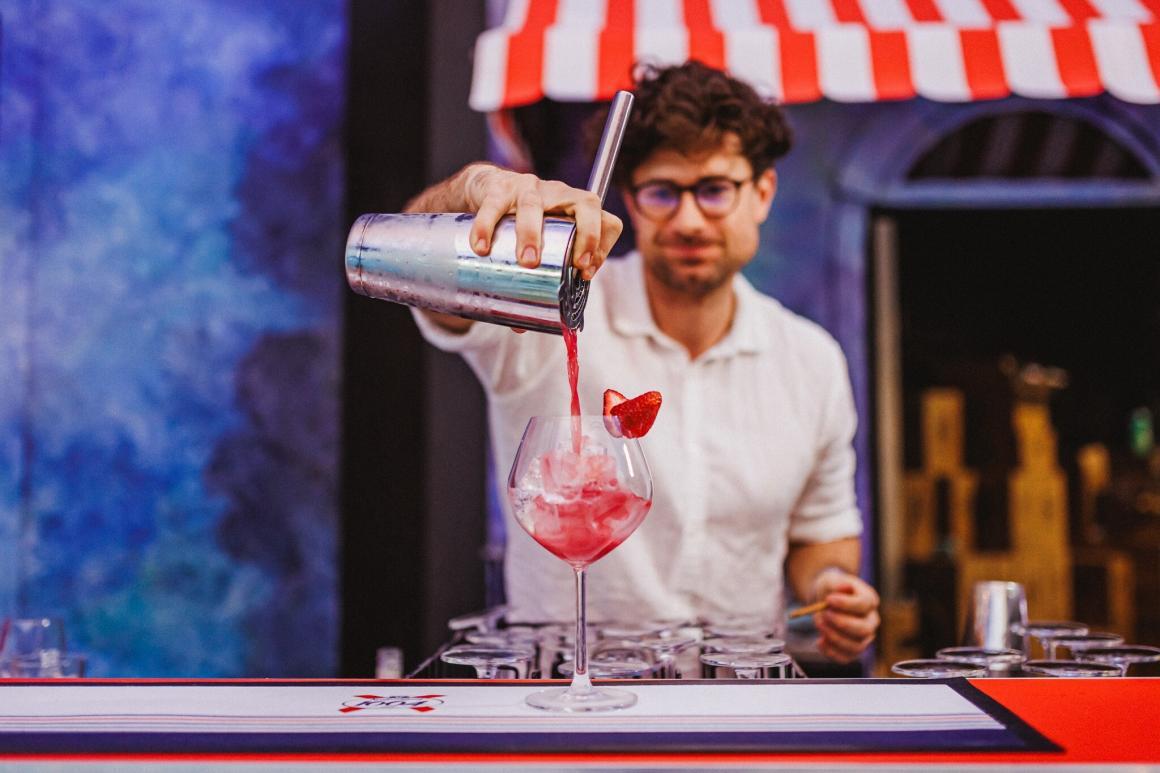 A bartender pouring a red cocktail at Monet in Paris