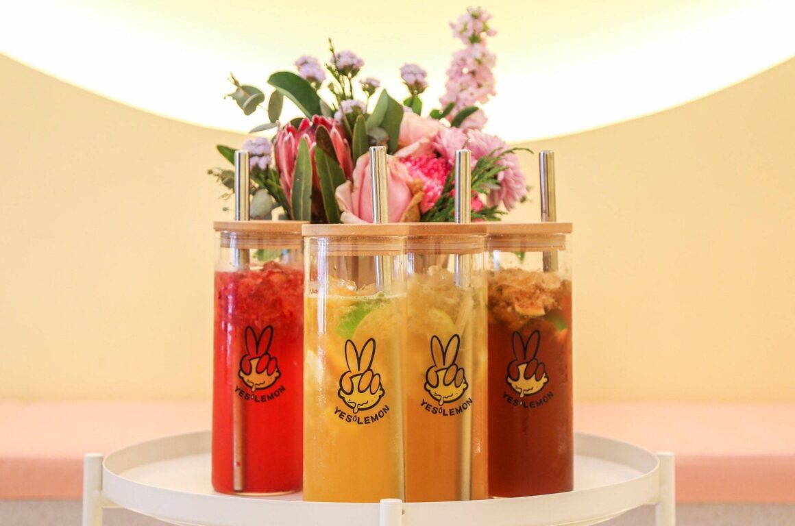 Four Yes Lemon bubble tea drinks sit on a table with flowers behind them in their Perth store