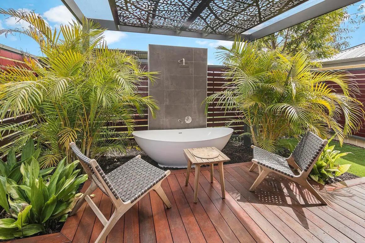 An outdoor bath/shower and patio setting in the outdoor area of 7th Heaven. One of the best accomodations in Busselton to stay at