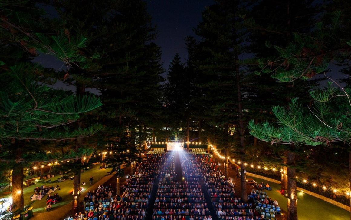 A birds eye view at night of the UWA Lotterywest Films venue. String lights line the trees with people filling the seats