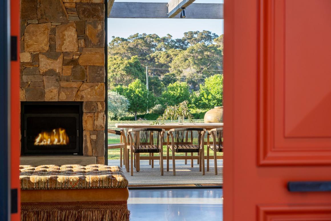 A view front the front door of the Ginahgulla Olive Estate showing the fireplace, outdoor seating area and olive tree view