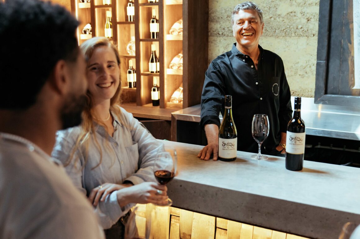 CEO of Swings and Roundabouts Andy Hopkins serves two visitors wine at the new cellar door
