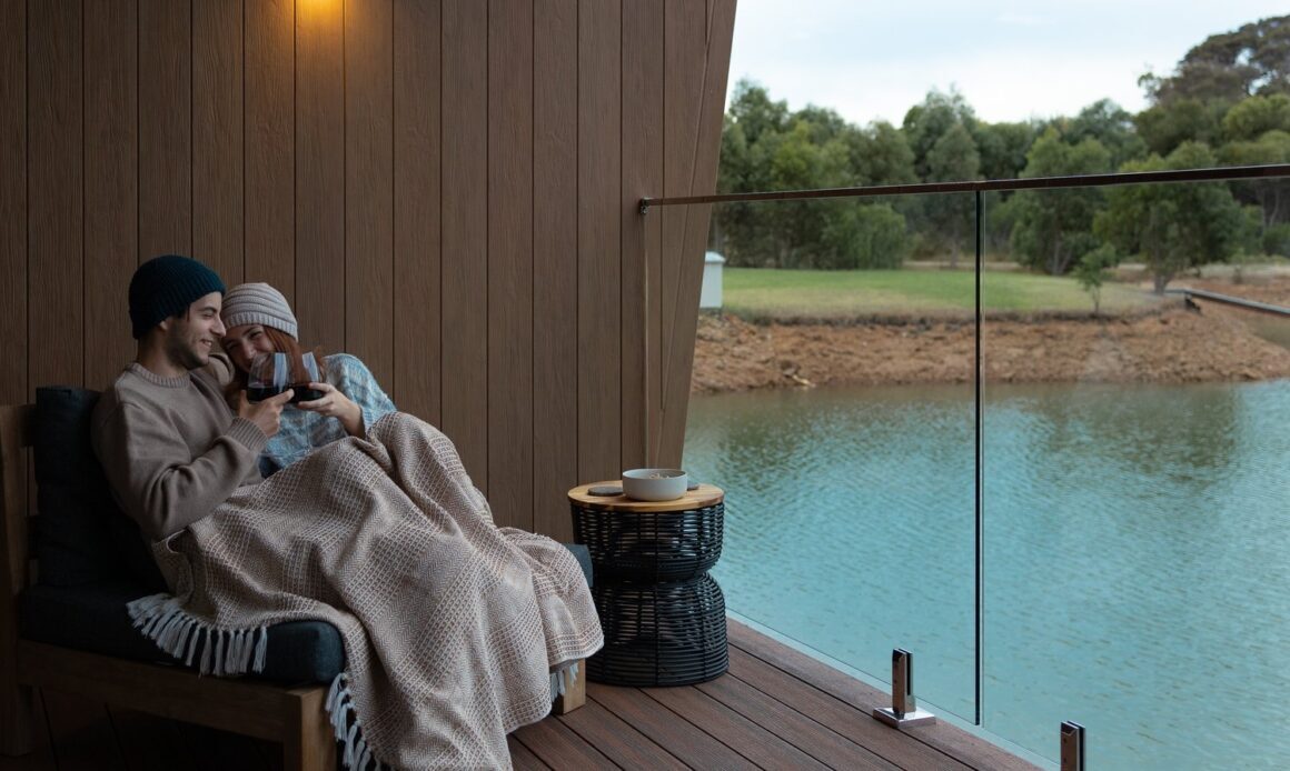 A couple sit on the patio at Edge Luxury Villas accomdation in Margaret River.