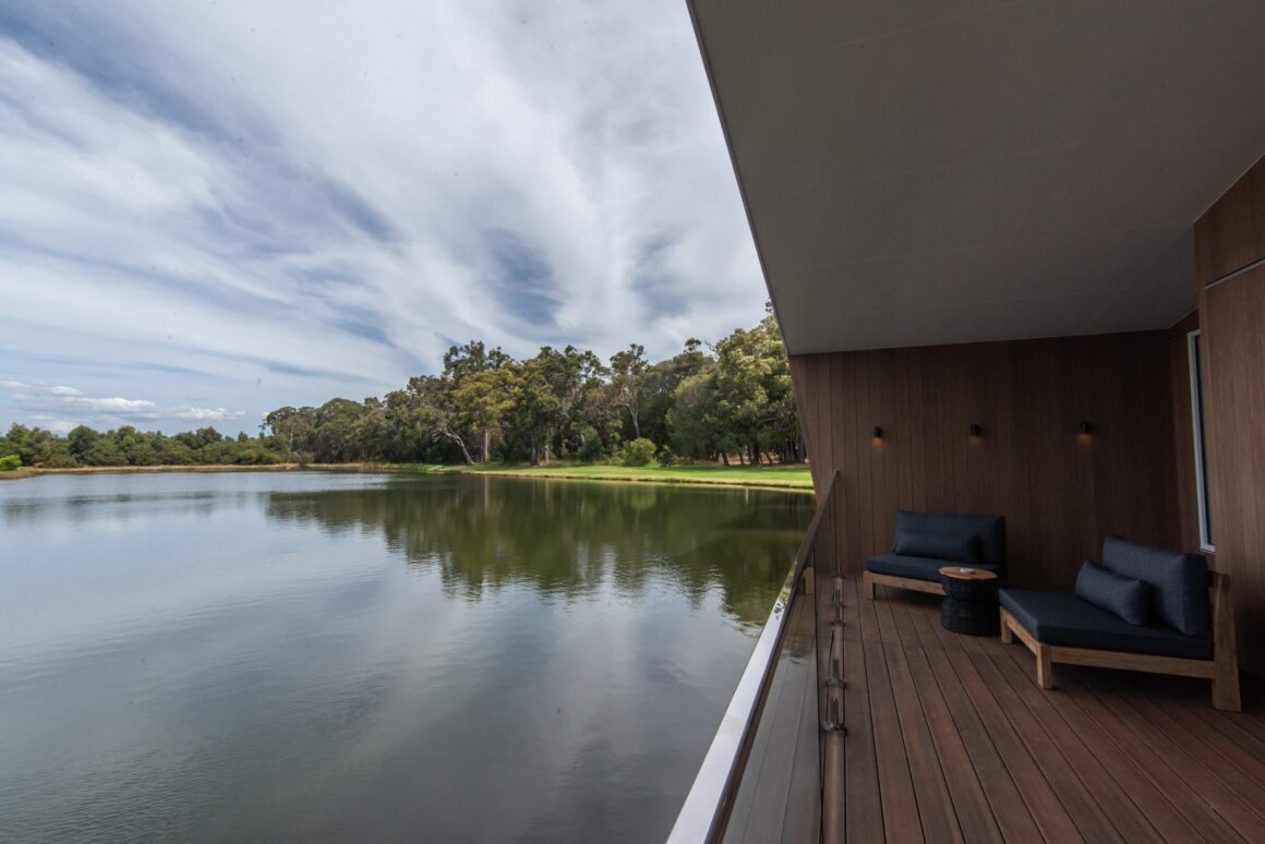 A side view showing the balcony with outdoor seating and the view over the lake