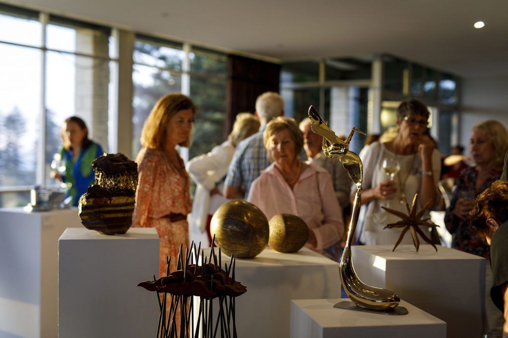 People gathered around at the Sculpture Inside exhibit looking at the art