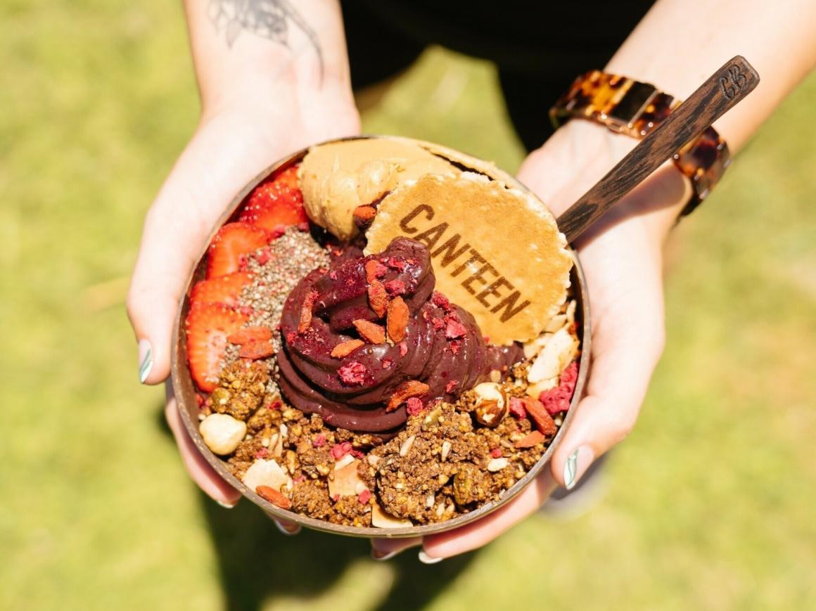 A woman holding a Canteen acai bowl, top down image