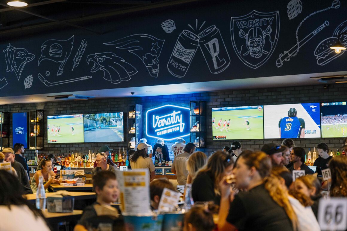 The inside of Varsity Cannington showing the bar and sports on TV