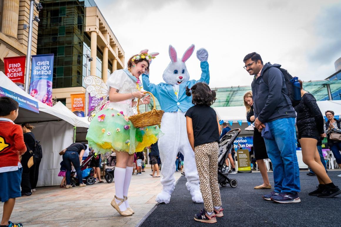 An Easter bunny and an Easter fairy with a child and his parent 