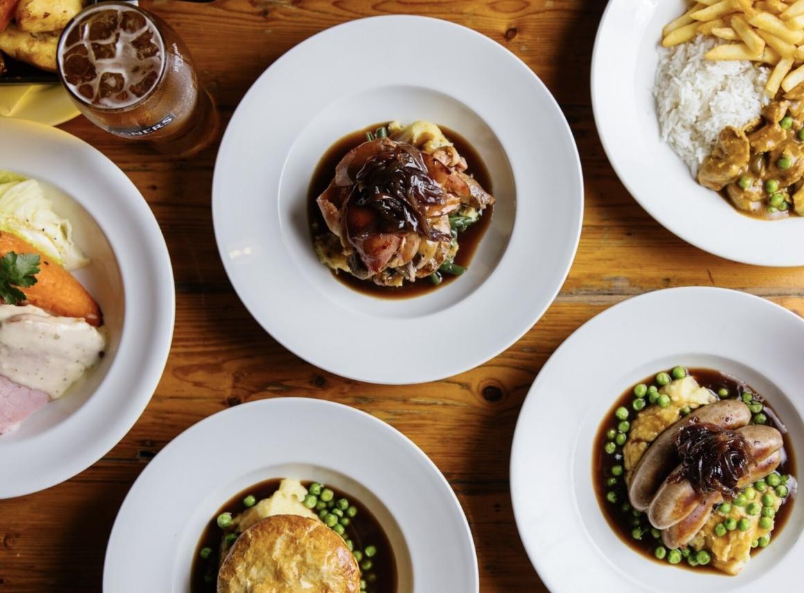 A top down view of traditional Irish roast dinners and a pint of Guinness