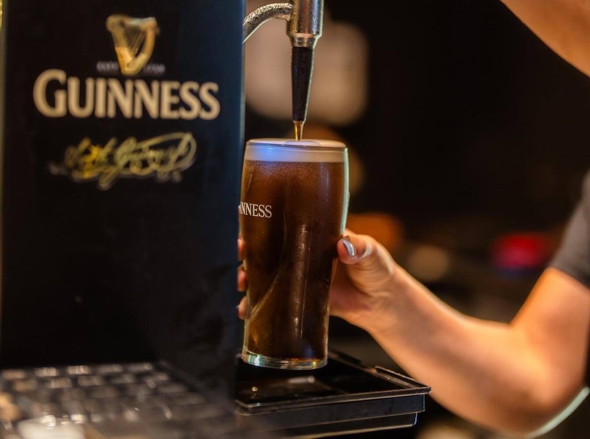 A bartender pouring a guinness pint