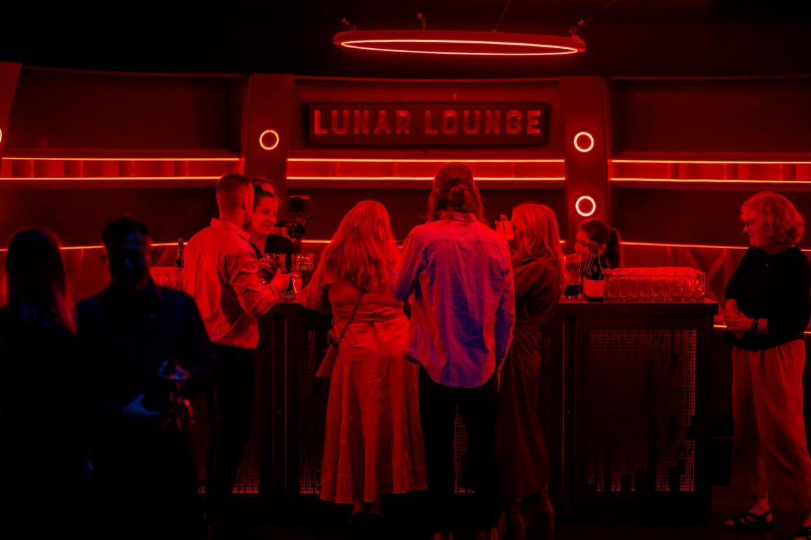 People gathered at the Lunar Lounge under red light