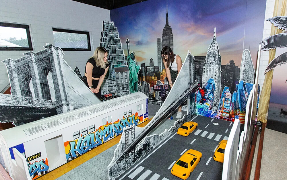 Two ladies putting around a NYC themed putt putt course at Hey Caddy