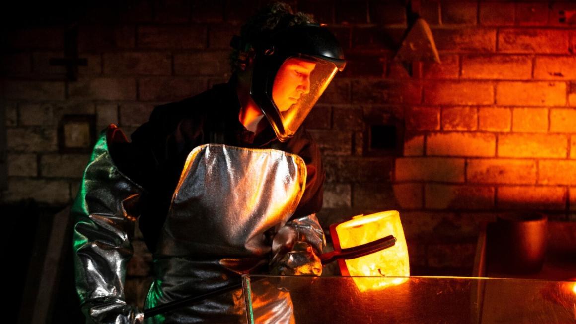 A person in safety gear pouring gold at the Perth Mint to celebrate their 125th anniversary