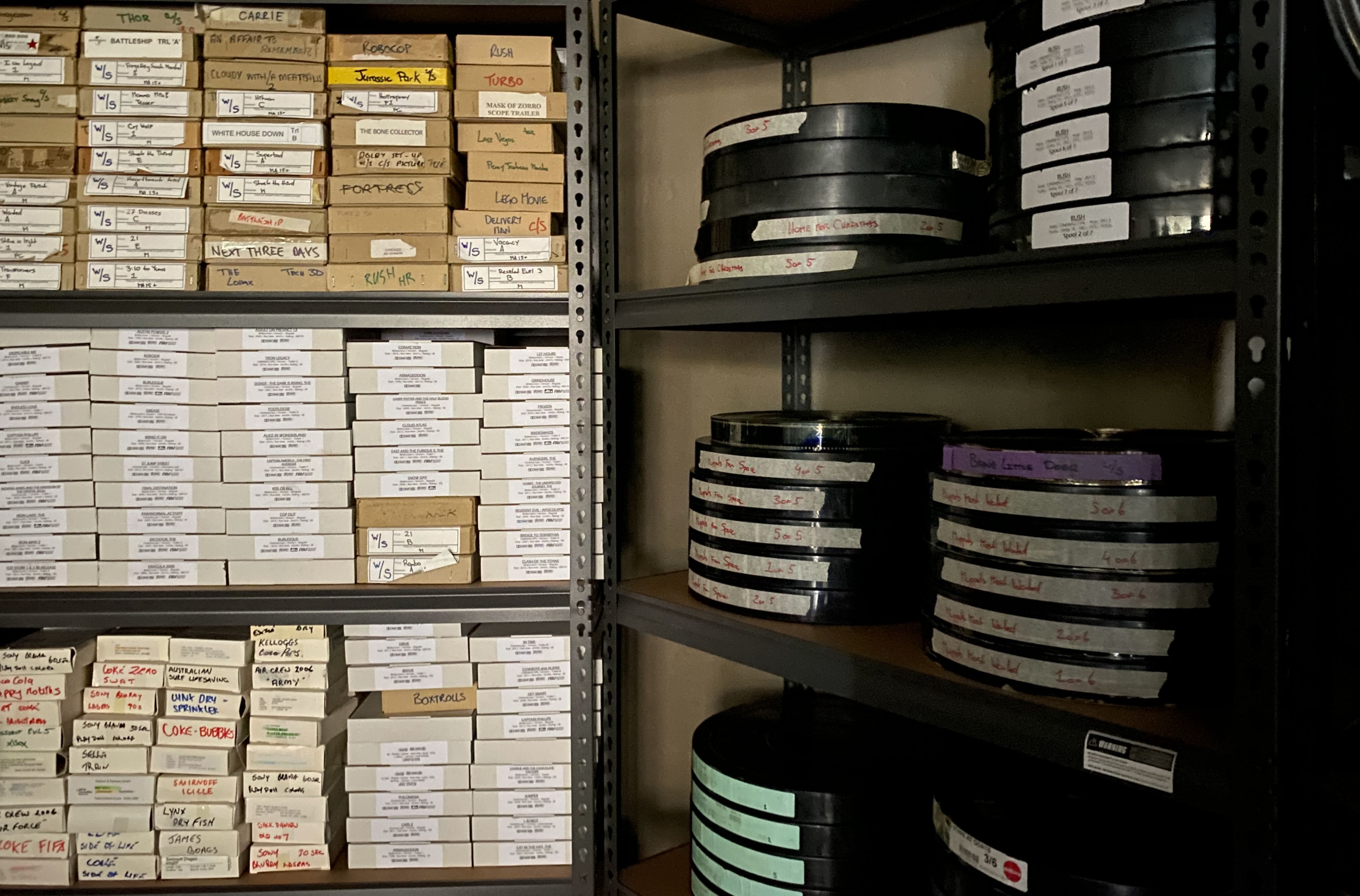 A stack of 15mm and 35 mm reels sit on shelves at Cygnet Theatre Como. For Exhumed cinema during Strange festival