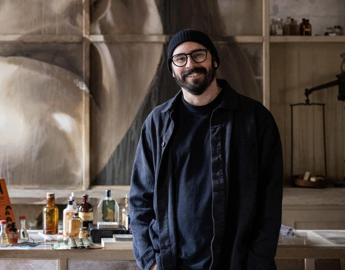 The artist Rone pictured in front of one of his artworks
