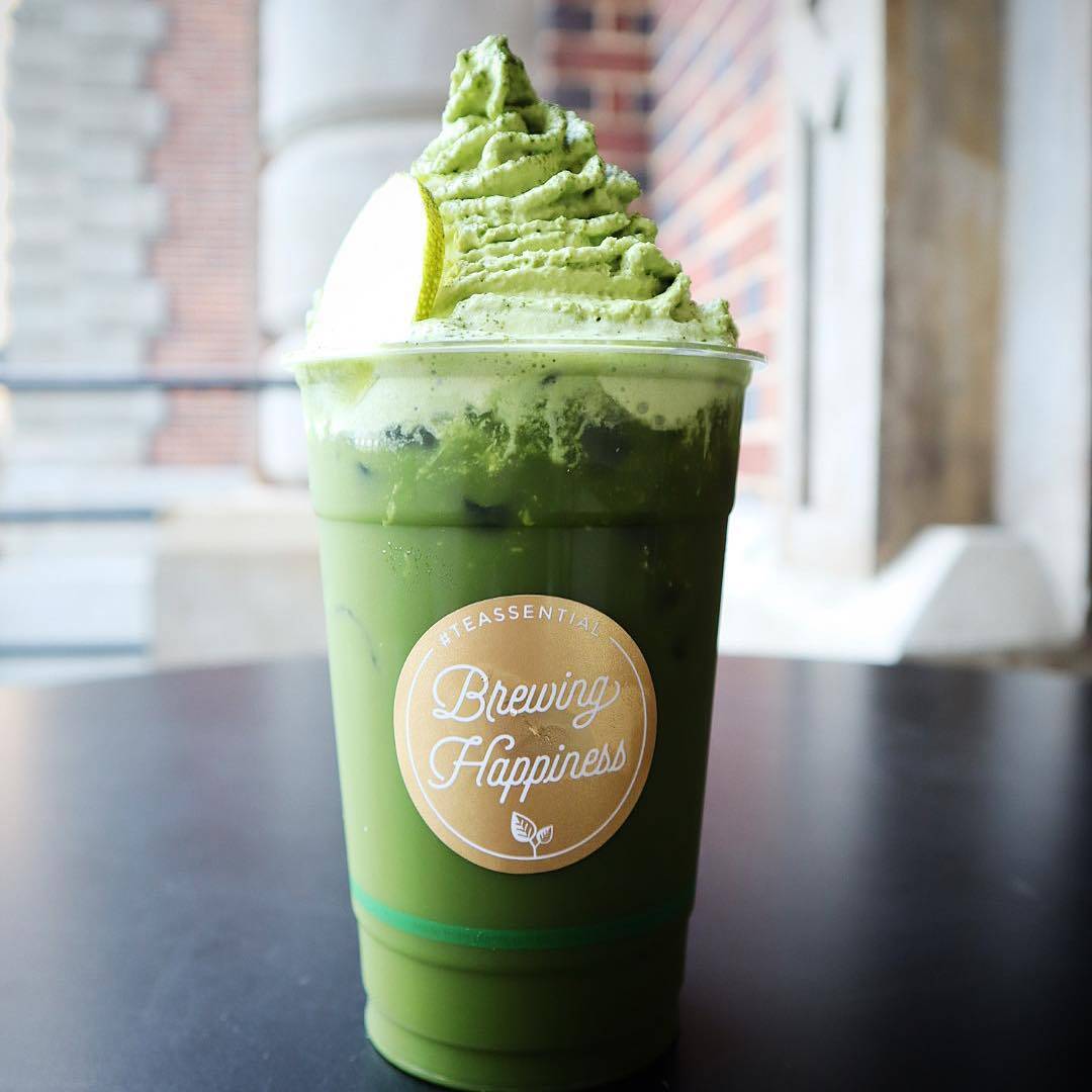 A cup of matcha latte from Teaessential on a bench in Perth