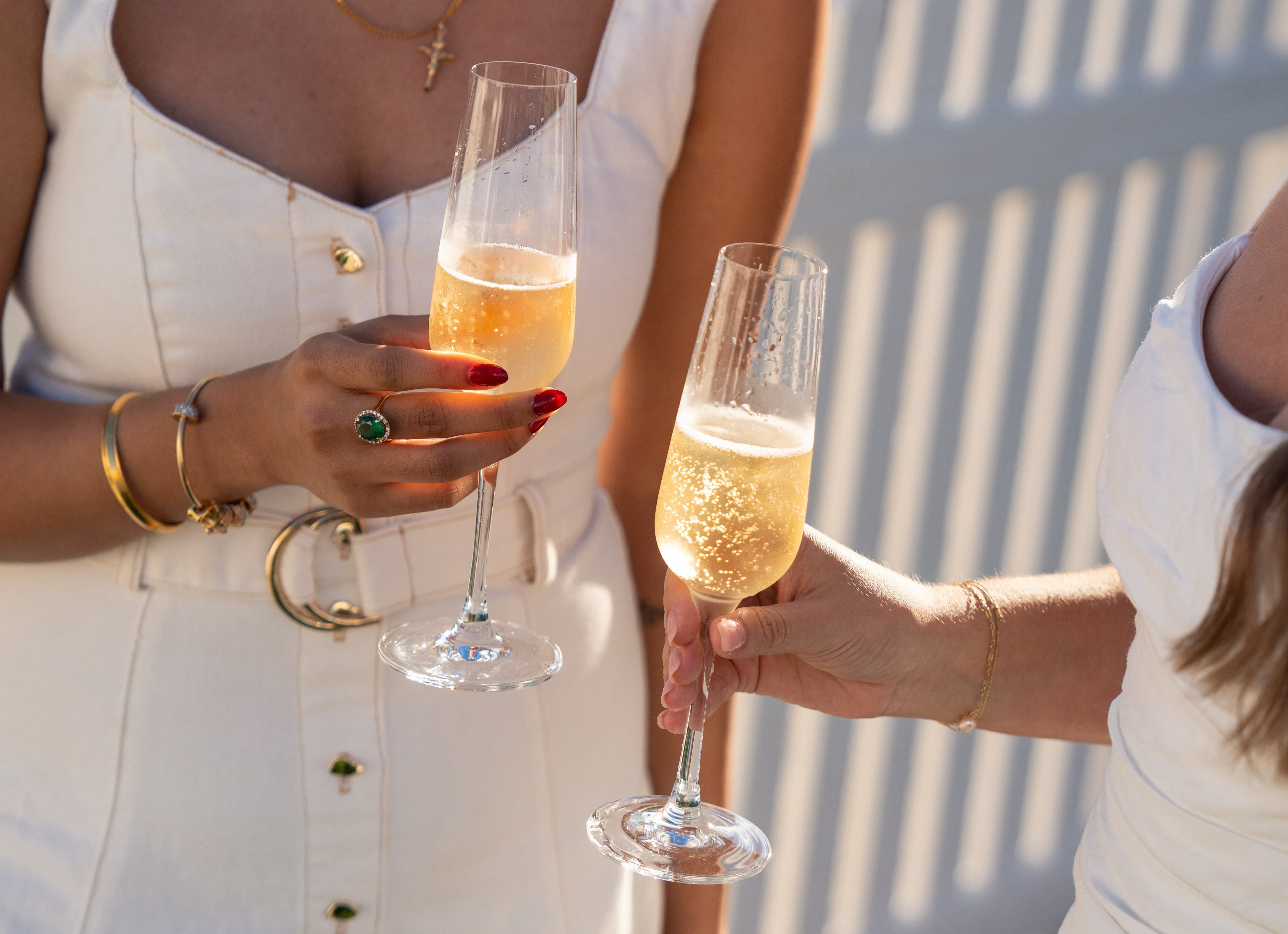 Two women holding champagne glasses at Perth's secret luxury white party, Le Diner en Blanc