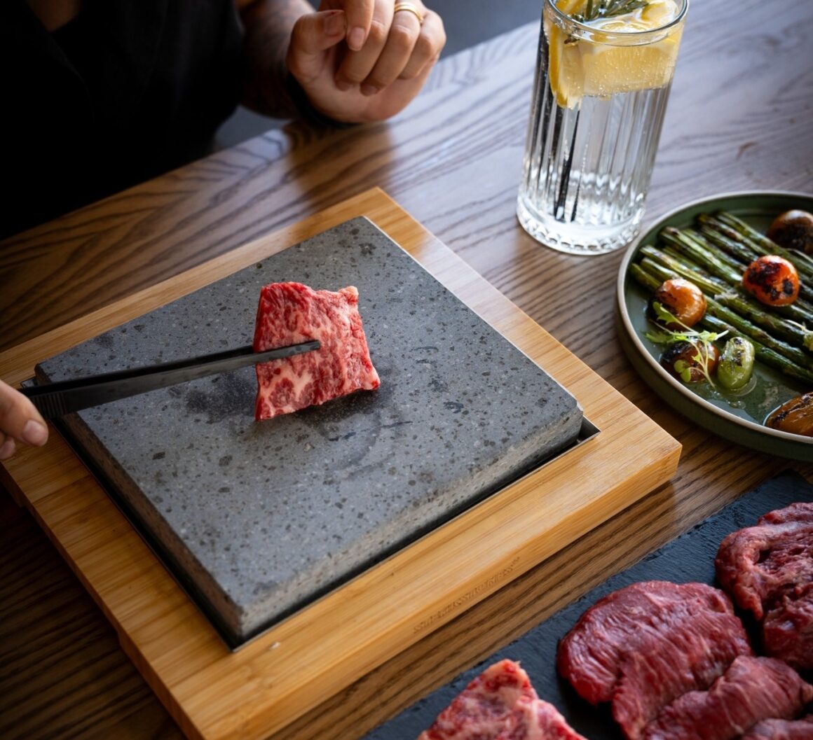 Cooking steak on a hot stone at Tipsy Cow Steakhouse, one of Perth's best steakhouses 