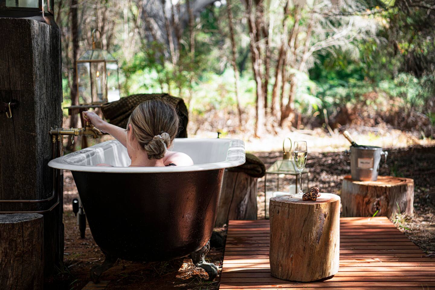 a woman taking a bath at the walk talk taste glamping tent down south 